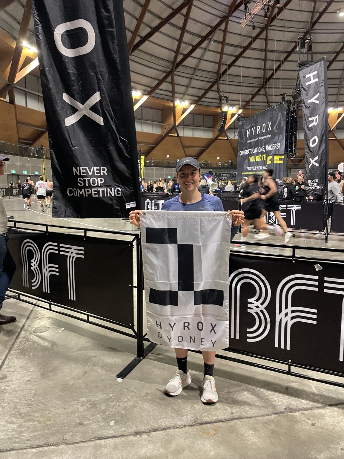 Issy Coombes holding the HYROX Sydney winners flag after qualifying for the 2025 World Championships